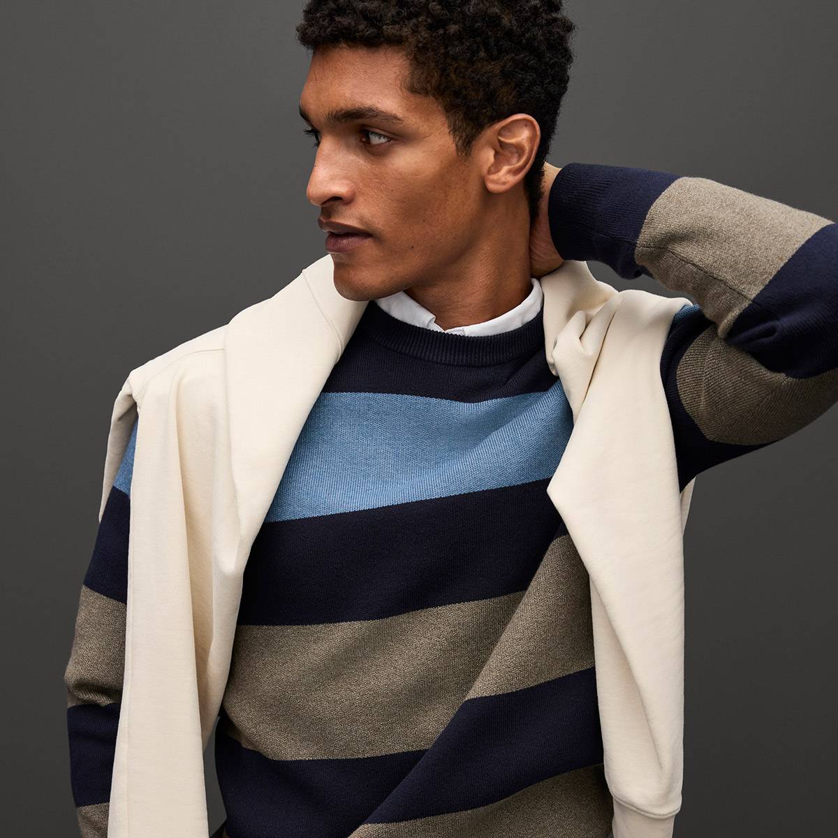 Model wearing brown and blue striped knitwear. Shop knitwear